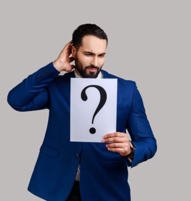 Confused bearded man holds question mark, finding smart solution